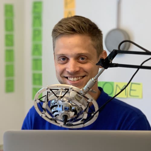 Kristian Emil Larsen smiler foran en mikrofon